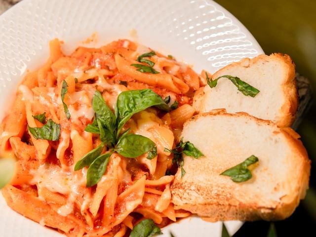 Penne in a creamy tomato sauce with fresh basil, served with toasted garlic bread.